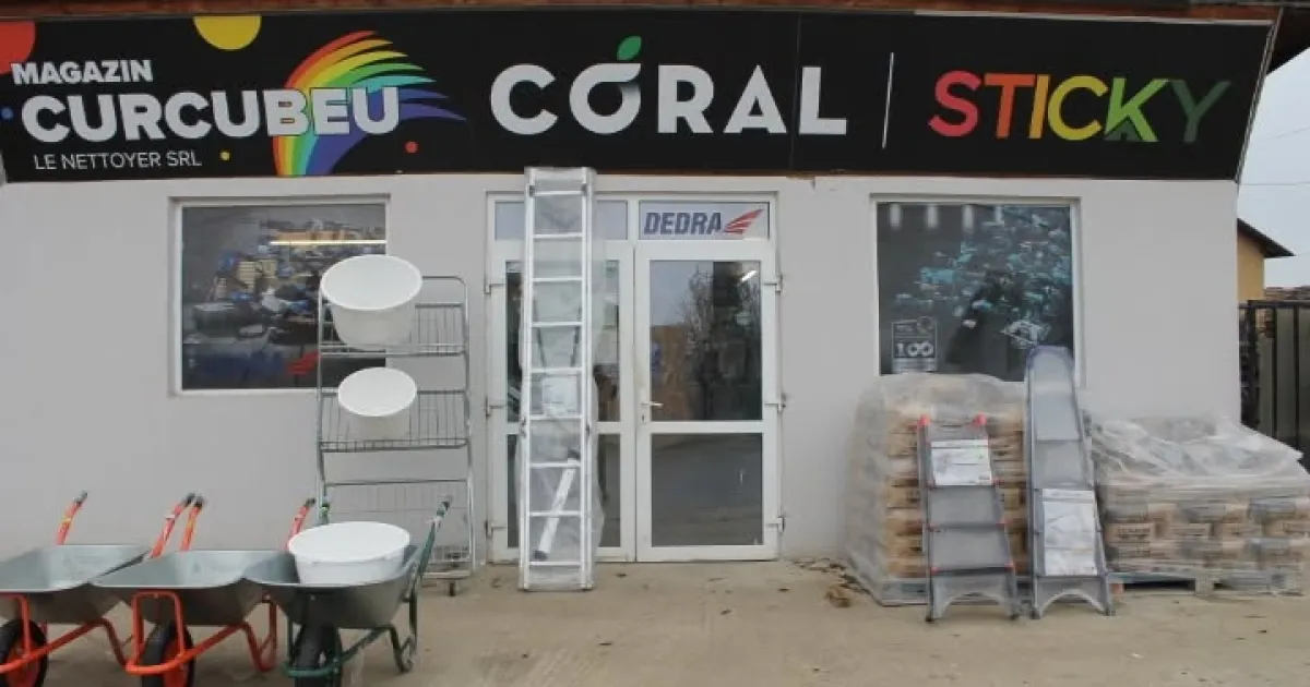 Fațada Magazinului Curcubeu, cu roabe, scări și paleți de materiale în față